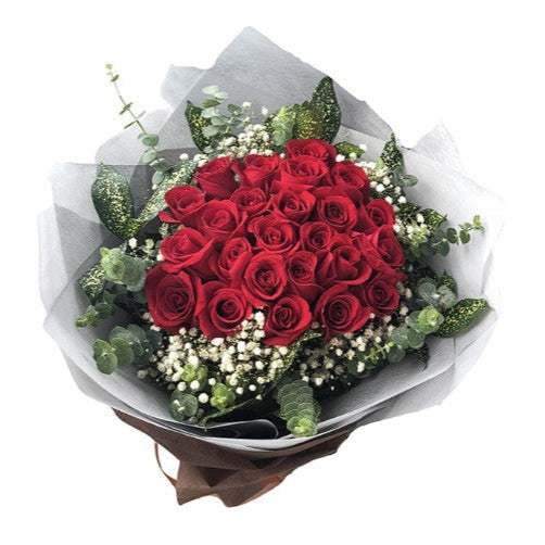 Bouquet of red roses with greenery on a white background